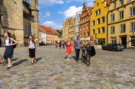 Studierende gehen durch die Altstadt von Osnabrck und schauen sich Geb?ude an.